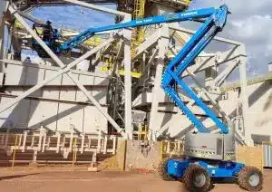 Plataforma aérea articulada em operação de trabalho em altura em galpão industrial – MunckMaq